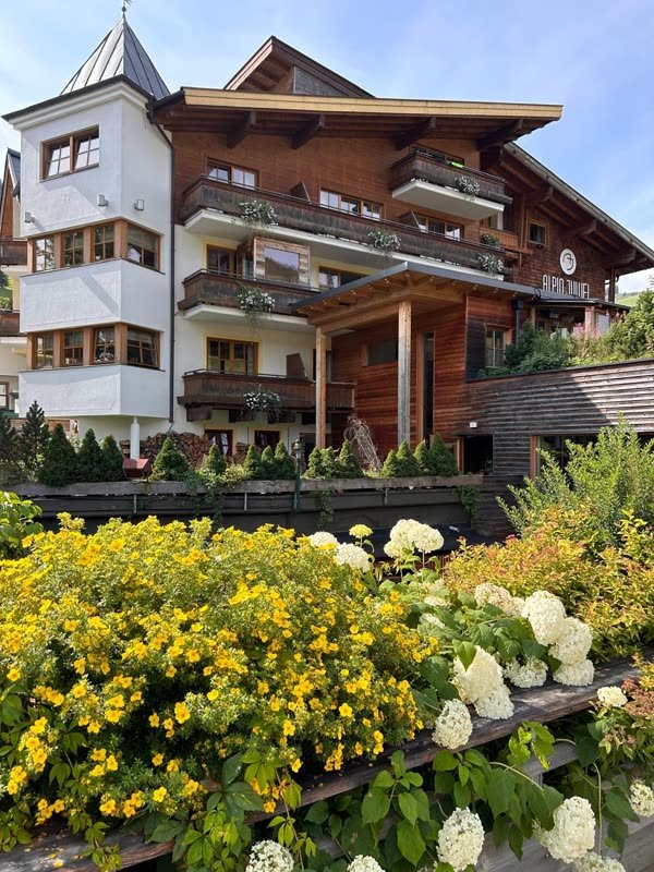 Hotelfront mit Blumenkästen und sommerlicher Bepflanzung