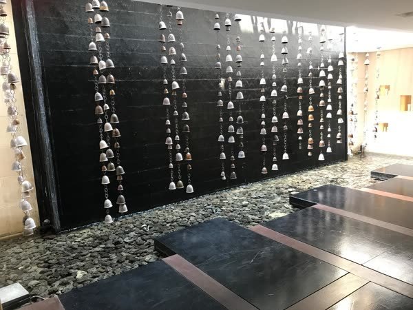 Wasserwand mit hunderten Glöckchen im Eingangsbereich