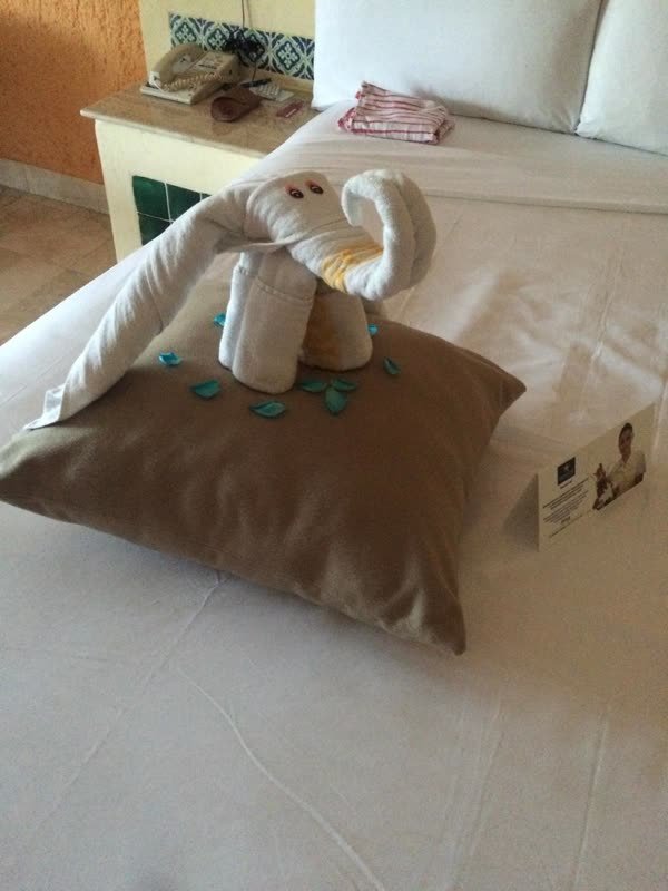 Kunstvoll gefaltete Handtuchfigur auf dem Bett im Zimmer