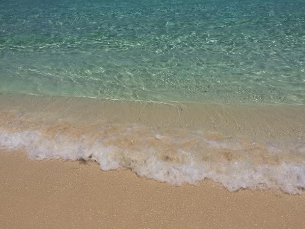 Türkisfarbenes, glasklares Wasser am karibischen Sandstrand