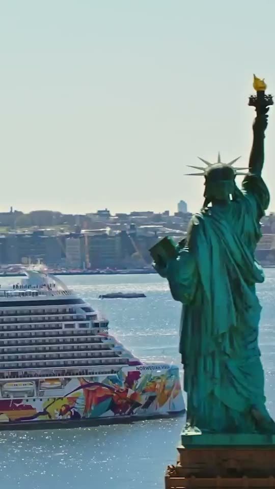 Freiheitsstatue in New York, dahinter ein Kreuzfahrtschiff
