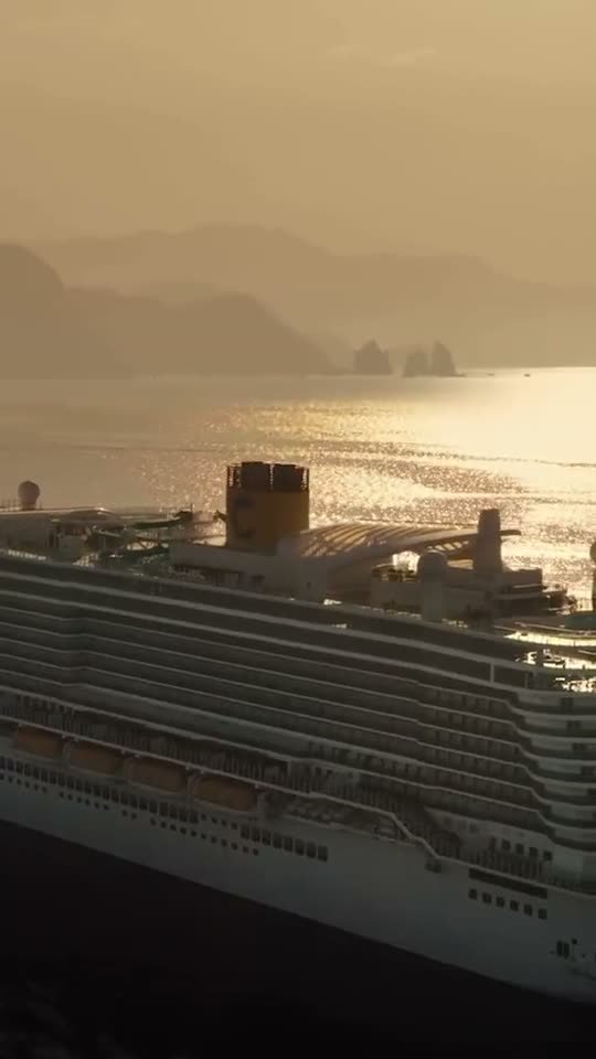 Kreuzfahrtschiff vor Bergkulisse im Abendlicht